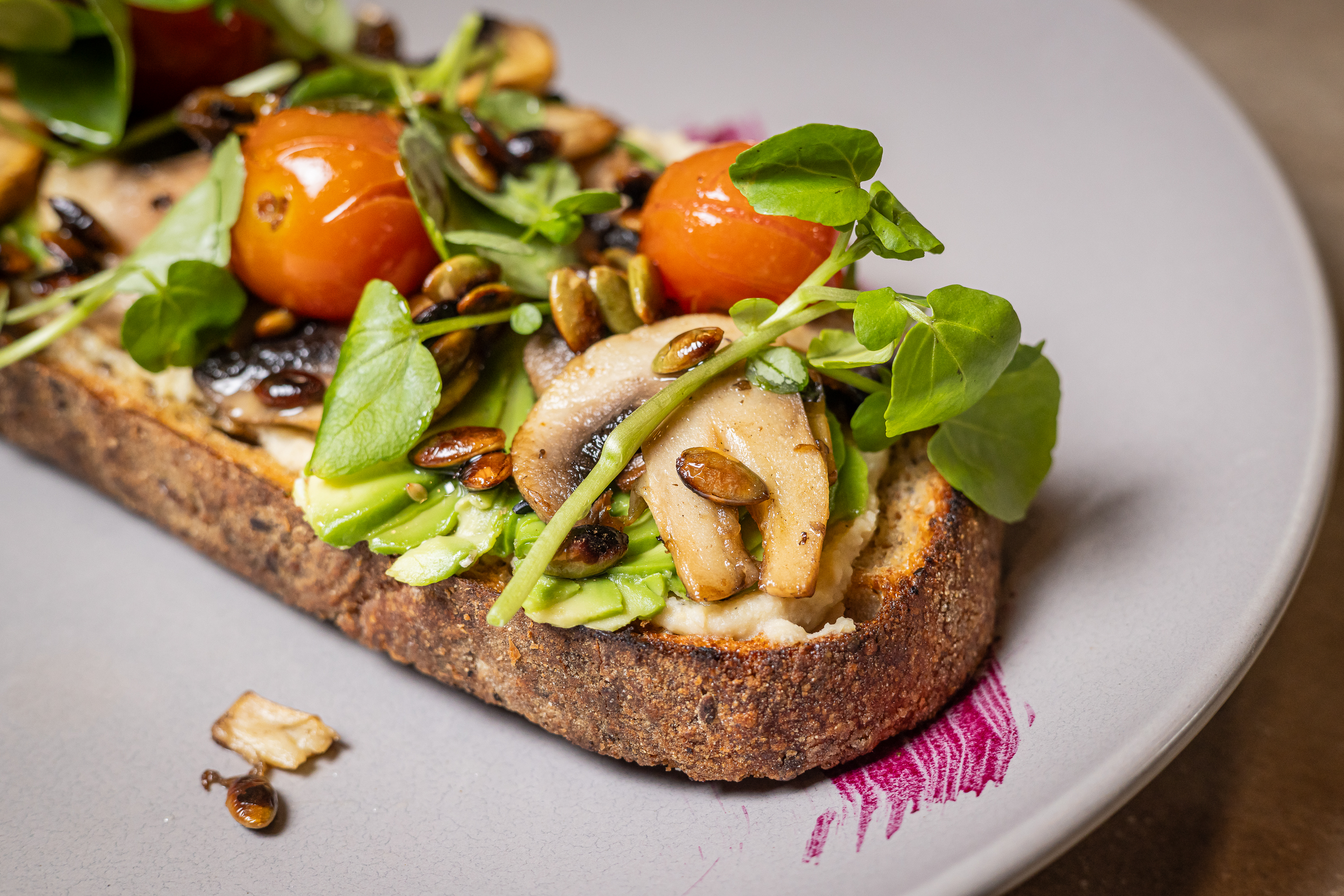 Tostada con palta, tomate cherry y brotes